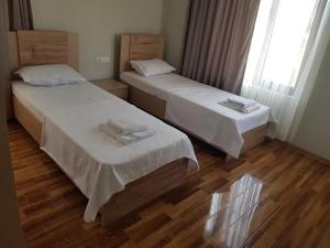 two beds in a room with wooden floors at VILLA DlAS in Ureki