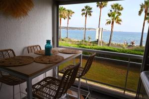 a table and chairs with a view of the ocean at Duplex de charme en bord de mer in Sanary-sur-Mer