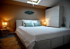 a bedroom with a large white bed with two pillows at Duplex de charme en bord de mer in Sanary-sur-Mer