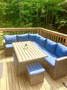 a blue couch and a table on a deck at Jewel Brook Cottage in Ludlow