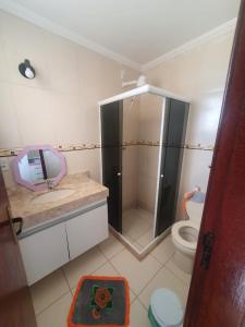 ein Badezimmer mit Dusche und Toilette in der Unterkunft Casa Balneário in São Pedro da Aldeia + 4 Fotos