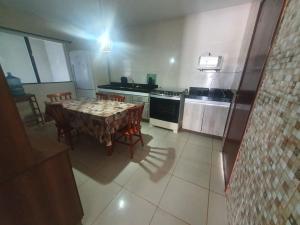 eine Küche mit Tisch und Stühlen und einem Herd in der Unterkunft Casa Balneário in São Pedro da Aldeia