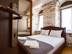a bedroom with a bed and a stone wall at Mansion 1887 in Limenas