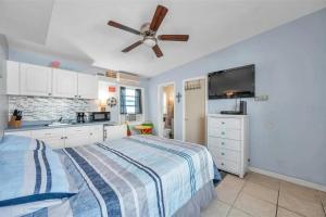 Wave condo في سانت بيتي بيتش: غرفة نوم بها سرير ومروحة سقف