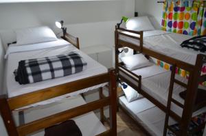 a bedroom with two bunk beds with white sheets at HostelariaSP Boutique in São Paulo