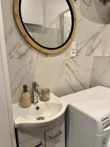 a bathroom with a sink and a mirror on the wall at Apartament Filmowy in Wałbrzych +8 photos