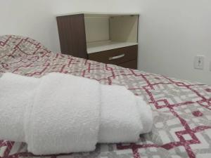a bed with two white towels on top of it at Apartamento Encantador 201 in Vitória da Conquista