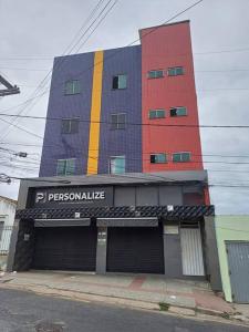 a tall building with a sign in front of it at Apartamento Encantador 201 in Vitória da Conquista