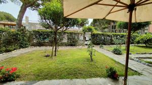 a garden with an umbrella and some flowers at A due passi dal mare in Portovenere