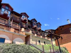 a building with wooden balconies on the side of it at Studio cabine chaleureux à Pyrénées 2000 - WiFi et parking privé in Bolquere Pyrenees 2000