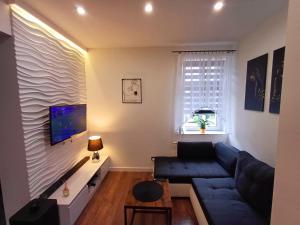 a living room with a blue couch and a tv at 4 You in Bolesławiec