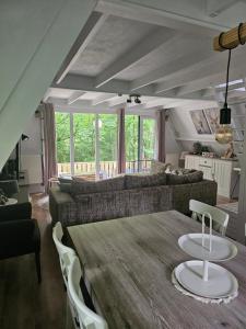 a living room with a table and a couch at Het Hertenbos Chalet 136 - Bos- Groene Oase- Rustmoment- Zwembad in Durbuy