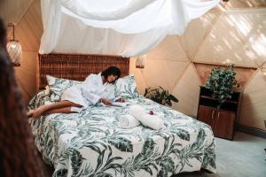 a woman is sitting on a bed with towels at AguaMar Vichayito in Vichayito