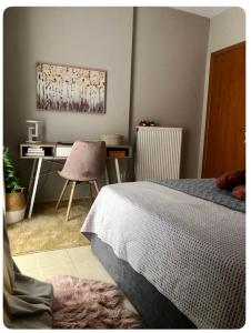 ein Schlafzimmer mit einem Bett und einem Schreibtisch mit einem Computer in der Unterkunft Rosemary modern house in the city center in Korinthos