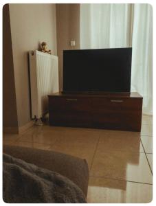 ein Wohnzimmer mit einem großen Fernseher auf einer Kommode in der Unterkunft Rosemary modern house in the city center in Korinthos