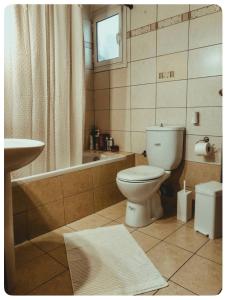 ein Badezimmer mit Toilette, Badewanne und Waschbecken in der Unterkunft Rosemary modern house in the city center in Korinthos + 4 Fotos