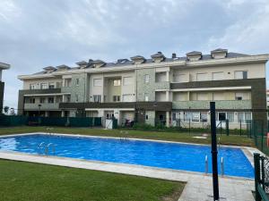 a building with a swimming pool in front of a building at V&B VACACIONAL in Suances