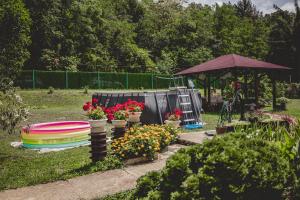 a garden with a group of flowers and an umbrella at Vikendica Fruškogorski kutak - Fruška Gora in Čerević