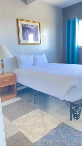 a bedroom with a large white bed and a table at Ocean Shores Inn & Suites in Ocean Shores