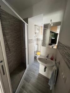 a bathroom with a sink and a shower and a toilet at Le casette nel cortile in Sciacca