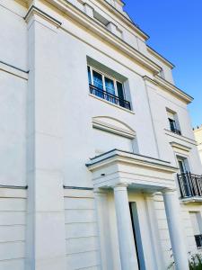 een wit gebouw met kolommen en ramen erop bij Modern Apartment Near Disneyland Paris in Serris +32 foto's