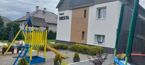 a playground in front of a house with a slide at Penzion Privat Siesta in Liptovský Mikuláš