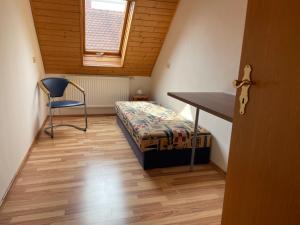 HeilsbronnにあるFerienwohnung Heilsbronnのベッドと机と椅子のある寝室