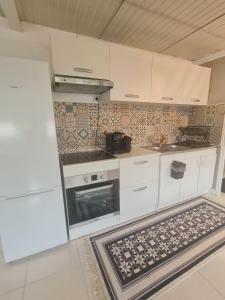 a kitchen with white cabinets and a stove top oven at Apparemment lumineux in Pierrefitte-sur-Seine