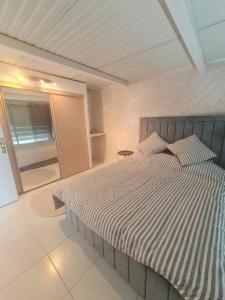 a bedroom with a bed with a striped comforter at Apparemment lumineux in Pierrefitte-sur-Seine +3 photos