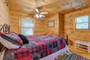 a bedroom with a bed in a log cabin at Pet-Friendly Bryson City Cabin with Fire Pit and Deck! in Bryson City