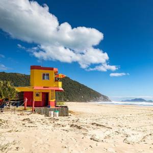 una casa amarilla y roja en la playa en Residencial Porto da Brava - NDI001, en Florianópolis