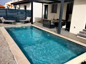 een zwembad voor een huis bij Rascola villa piscine 4 étoiles in Le Boulou