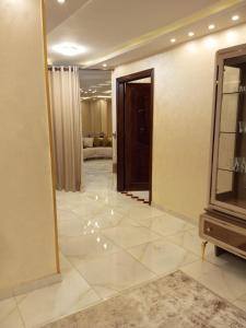 a room with a hallway with a mirror and a television at ارقي شقه فندقيه بالمنصوره واطلاله كامله علي النيل in Ṭalkha