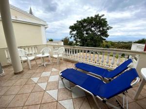 een patio met stoelen en tafels op een balkon bij Cozy Maisonette Rebecca in Hanioti