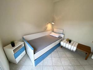 een kleine slaapkamer met een blauw en wit bed bij Cozy Maisonette Rebecca in Hanioti