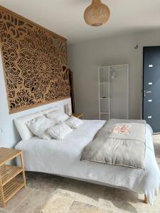 a bedroom with a large white bed and a wooden table at A Casa Vadiiolina - Chambres d'hôtes d'exception in Sollacaro