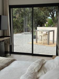 a bedroom with a bed and a view of a table at A Casa Vadiiolina - Chambres d'hôtes d'exception in Sollacaro +15 photos