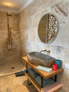 a bathroom with a stone sink and a mirror at A Casa Vadiiolina - Chambres d'hôtes d'exception in Sollacaro