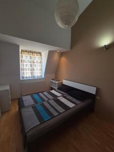 a bedroom with a bed in a room with a window at VORTEX Apartment Skopje in Skopje