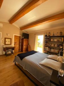 a bedroom with a bed and a desk and a window at Villa avec piscine, location à la semaine in Montauroux