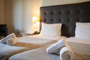 a hotel room with two beds with towels on them at Aktaion Resort in Gythio