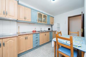 a kitchen with wooden cabinets and a table with a chair at Apartamento Los Llanos 1-L1 in Vecindario