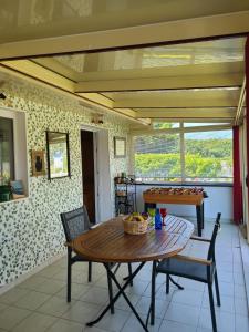 une salle à manger avec une table et des chaises et une fenêtre dans l'établissement Villa " Rosina ", à Fort-Mahon-Plage