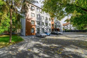 ein Parkplatz mit vor einem Gebäude geparkten Autos in der Unterkunft KOA - Davino Aparthotel in Braşov