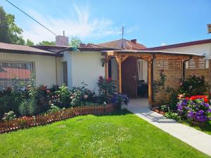 a house with a garden with flowers in the yard at Domki u Magdy in Ustka