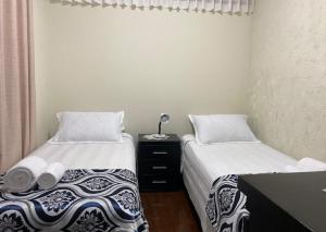 a bedroom with two beds and a desk with a lamp at El Sosiego en Cochabamba in Cochabamba