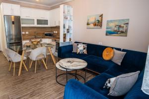 a living room with a blue couch and a table at Sunnydream Apartaments Saranda in Sarandë