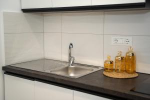 a kitchen counter with a sink and two bottles at Sunnydream Apartaments Saranda in Sarandë +52 photos