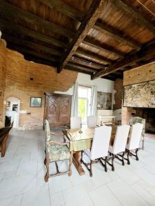 a dining room with a table and white chairs at Domaine d'en serres, 15th century castle in Saint-Marcel-Paulel