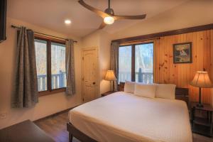 Schlafzimmer mit einem Bett, einem Deckenventilator und Fenstern in der Unterkunft Fabulous 4Bed 3 bath Cottage Pool Hot tub Games in Gatlinburg + 38 Fotos